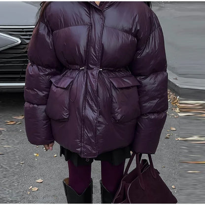 Person wearing a purple puffer coat in an outdoor setting