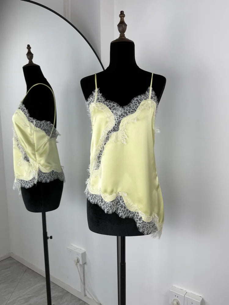 Light yellow lace-trimmed top on a mannequin against a white wall.