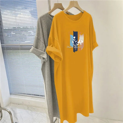 Yellow dress with a graphic design on a hanger near a window.