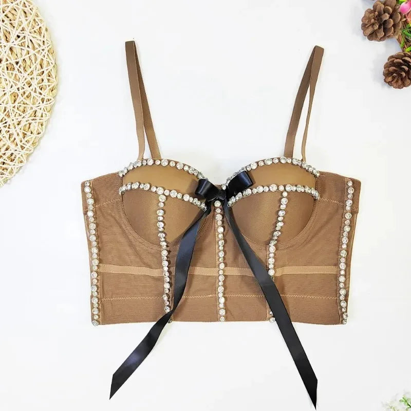 Brown bra with pearl details and a black ribbon on a white background