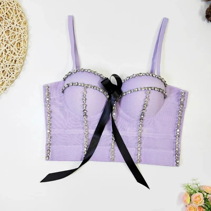 Lavender bralette with decorative chains and a black ribbon on a white background