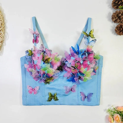 Light blue children's top with colorful butterfly designs on a white background