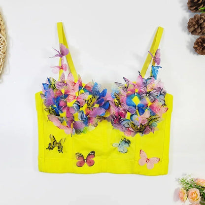 Yellow bikini top with colorful butterfly designs on a white background