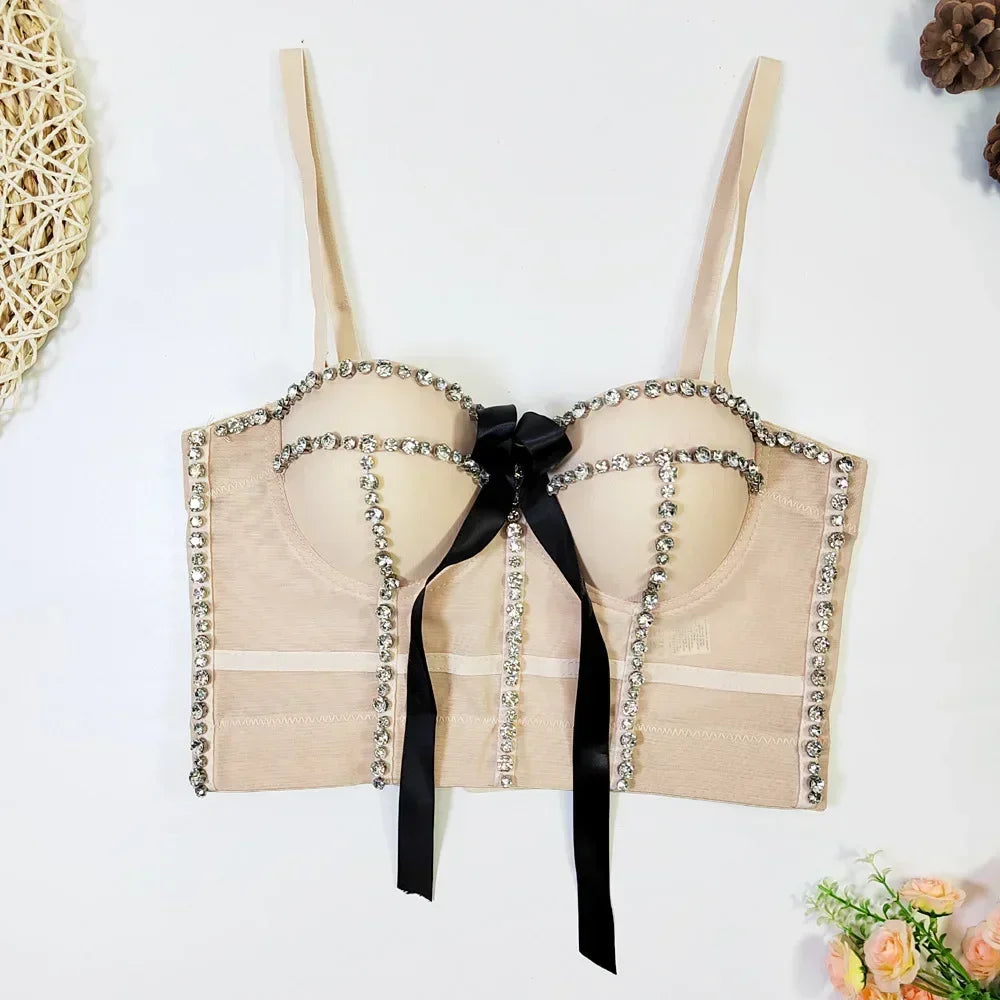Beige bra with decorative chains and a black ribbon on a white background