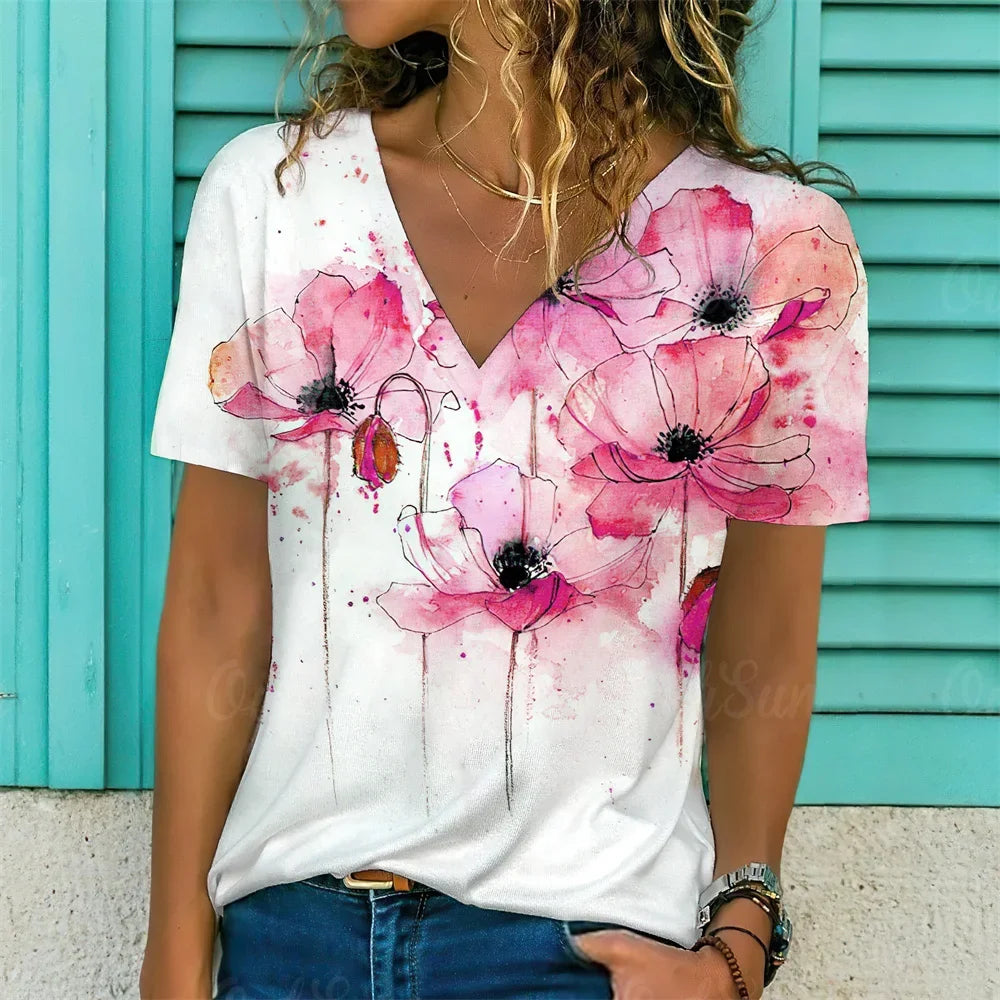 Person wearing a white t-shirt with pink floral designs against a turquoise background