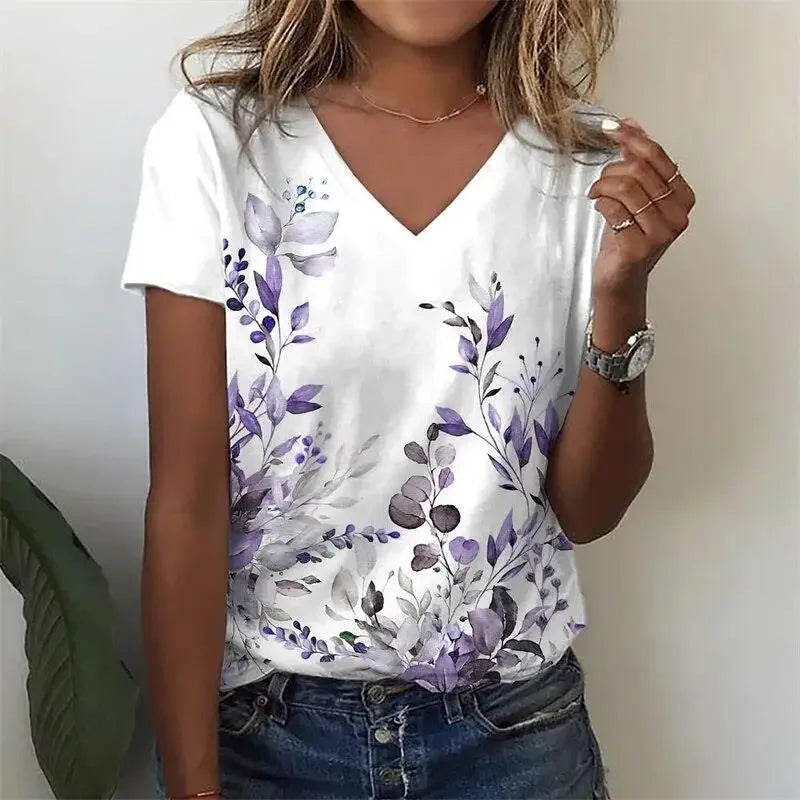 Person wearing a white t-shirt with purple floral design against a plain background