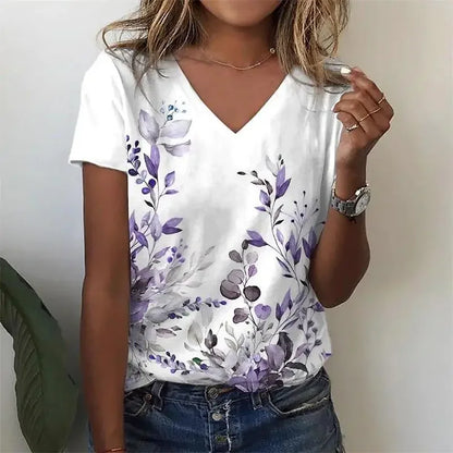 Person wearing a white t-shirt with purple floral design against a plain background