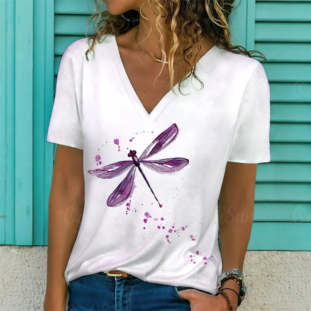 Person wearing a white t-shirt with a purple dragonfly design against a teal background