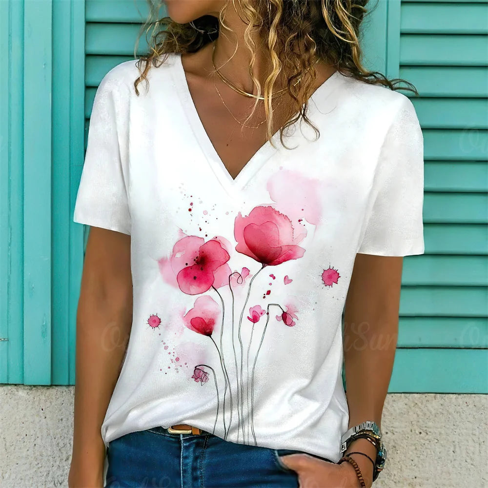 Person wearing a white t-shirt with pink floral design against a turquoise background