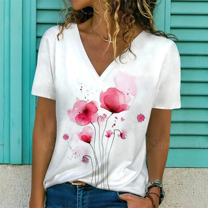 Person wearing a white t-shirt with pink floral design against a turquoise background