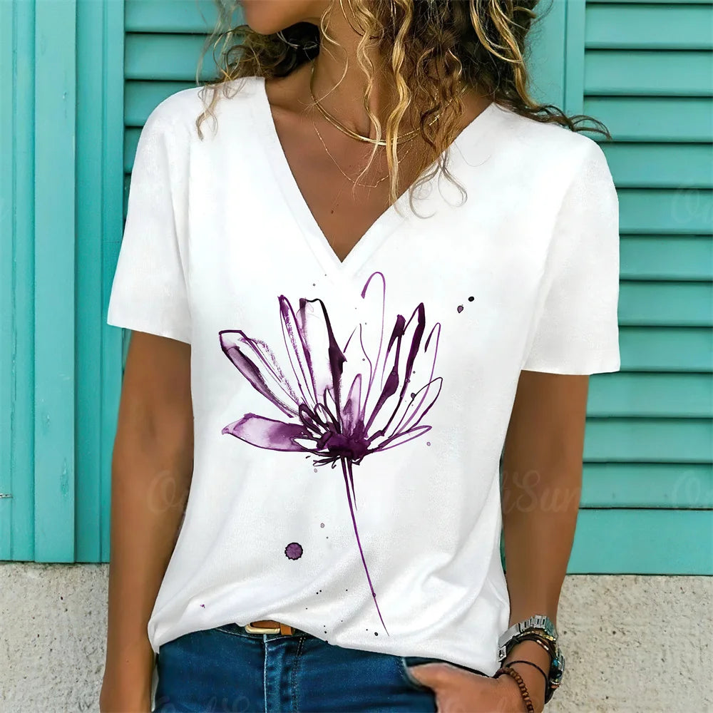 Person wearing a white t-shirt with a purple floral design against a turquoise background