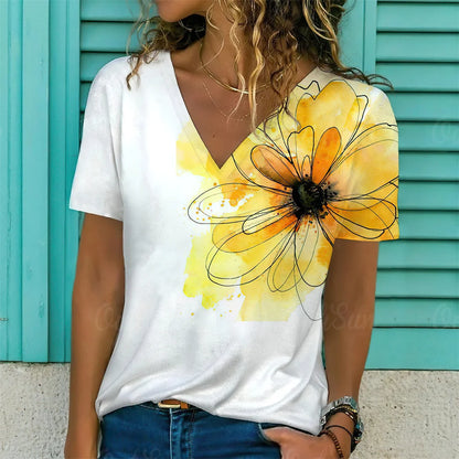 Person wearing a white t-shirt with a large yellow flower design against a turquoise background.
