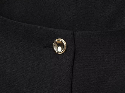 Close-up of a black fabric with a gold button