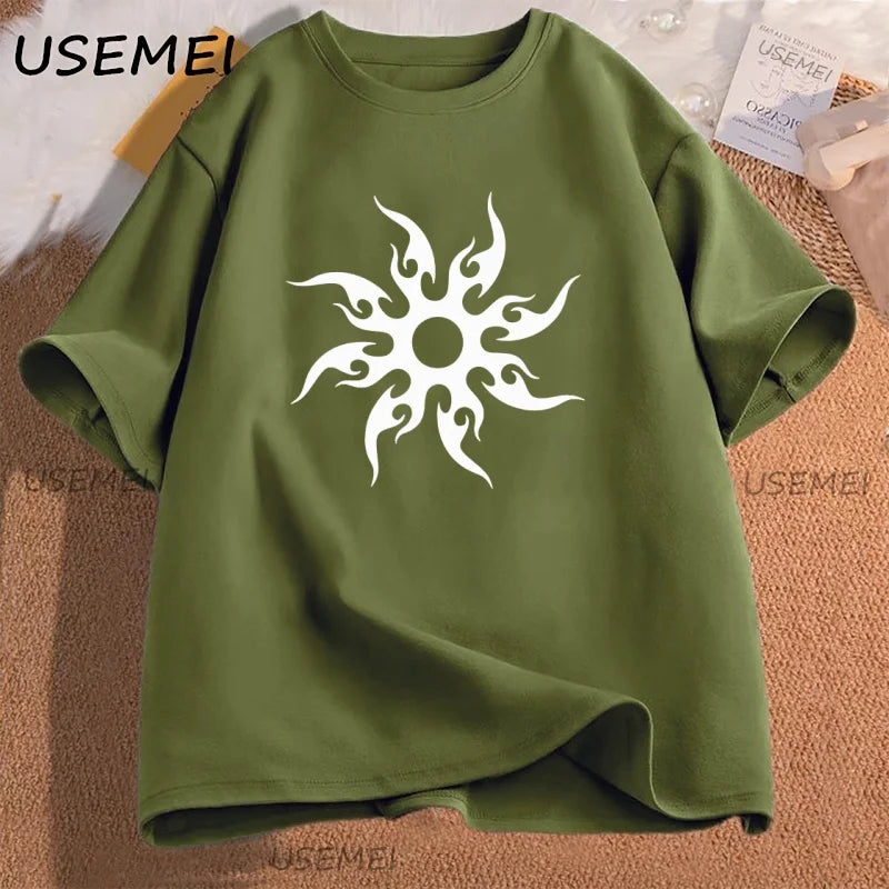 Green t-shirt with a white tribal sun design on a textured surface