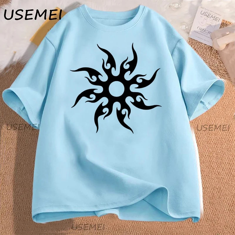 Light blue t-shirt with black tribal sun design on a textured surface