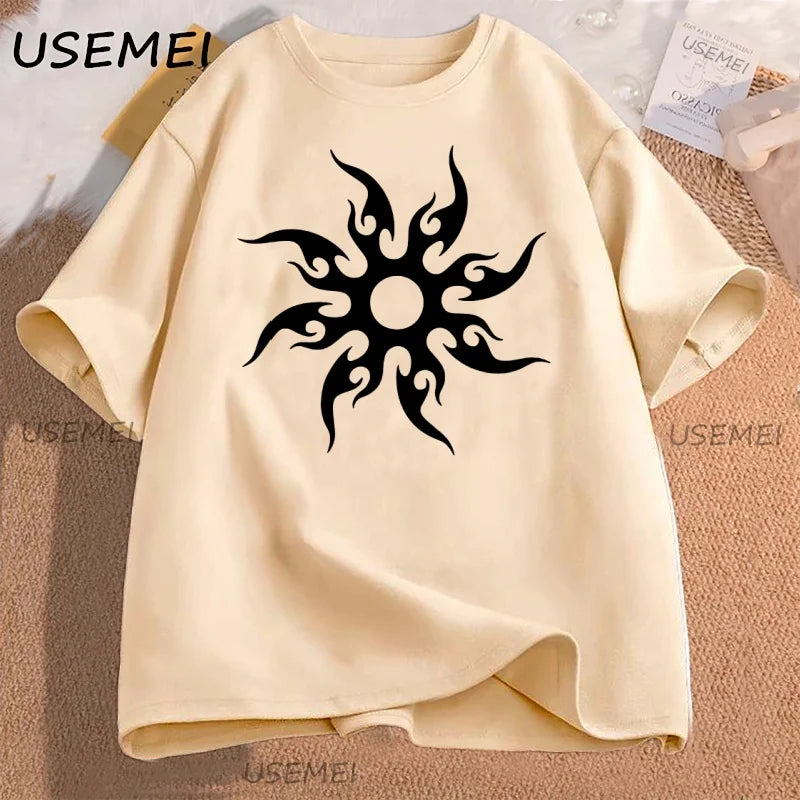 Beige t-shirt with black tribal sun design on a textured surface