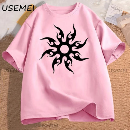 Pink t-shirt with black tribal sun design on a textured surface