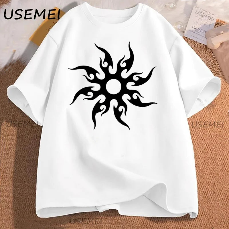 White t-shirt with black tribal sun design on a textured surface, featuring the brand 'USEMEI'.