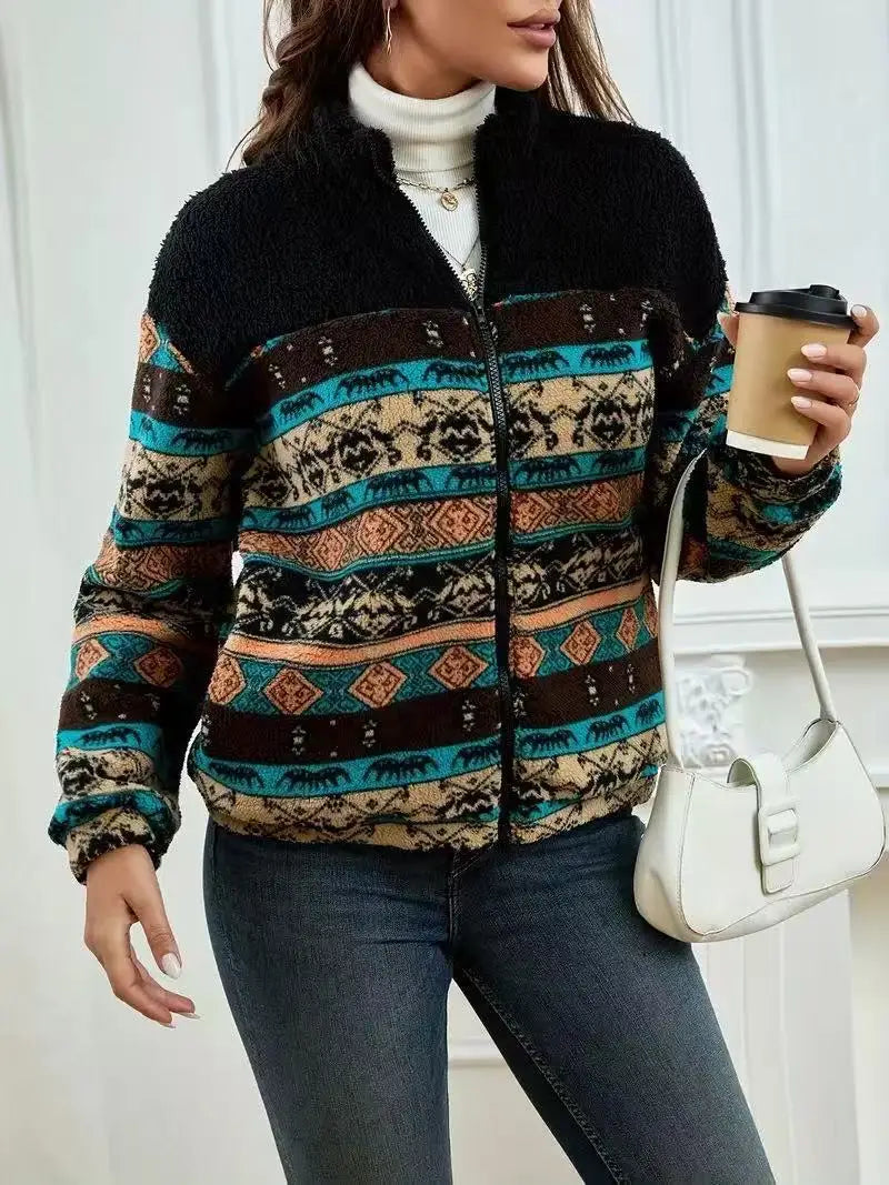 Person wearing a patterned jacket holding a coffee cup indoors.
