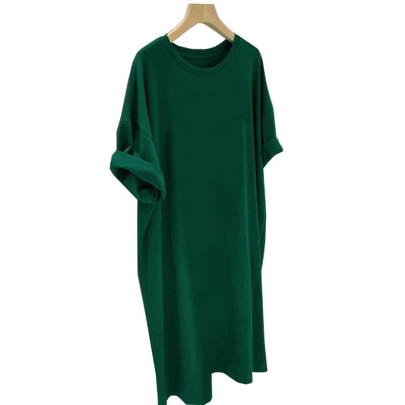 Green dress on a wooden hanger against a white background