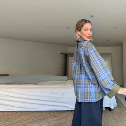 Woman wearing a blue plaid shirt in a bedroom setting