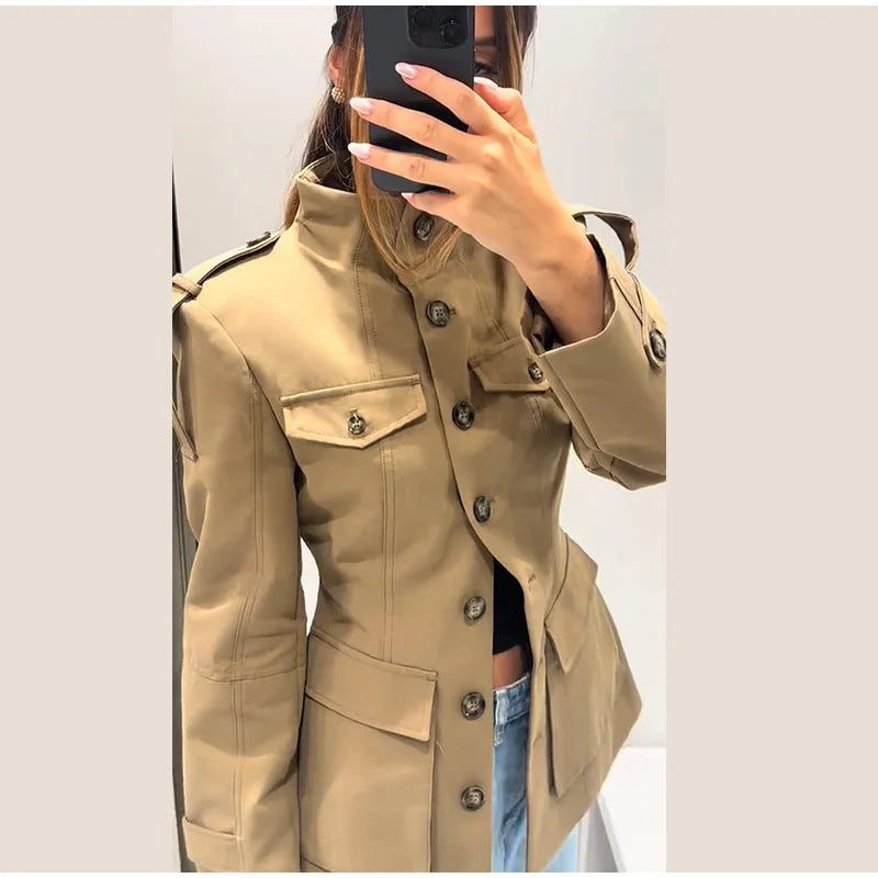 Beige trench coat worn by a person, with a plain background