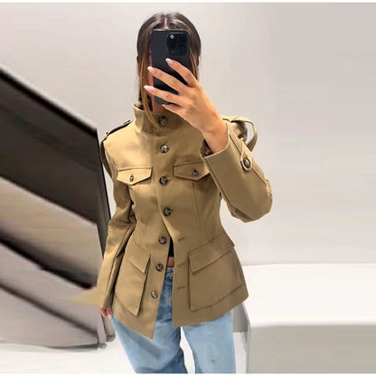 Person wearing a beige trench coat taking a mirror selfie.