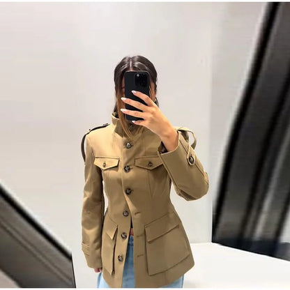 Person wearing a beige trench coat taking a mirror selfie.