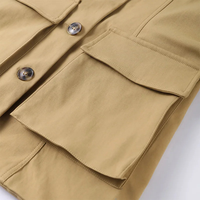 Close-up of a beige jacket with buttons and a pocket on a white background