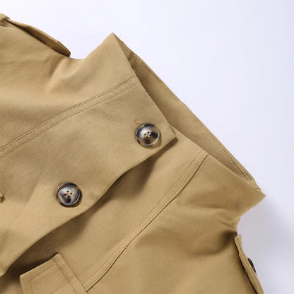 Close-up of a beige trench coat with button details on a light gray background