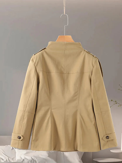Beige jacket on a hanger against a neutral background