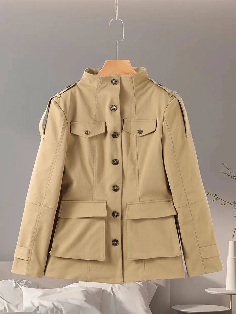 Beige jacket on a hanger against a gray background