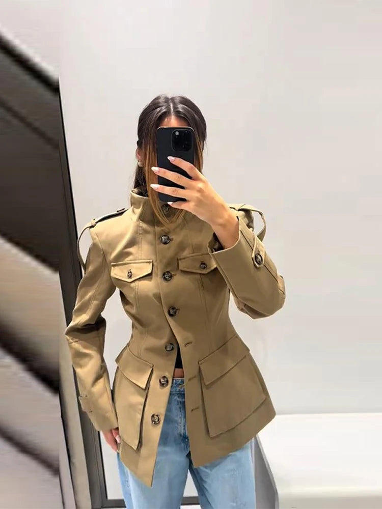 Person wearing a beige trench coat taking a mirror selfie.