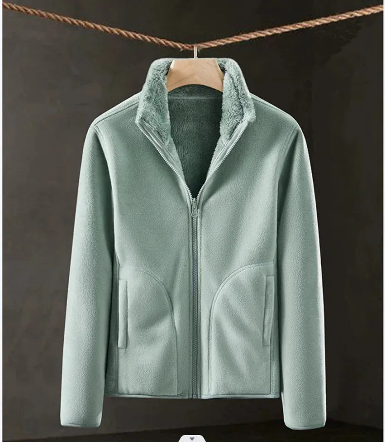 Light green fleece jacket with a hanger on a dark background