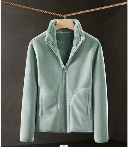 Light green fleece jacket with a hanger on a dark background