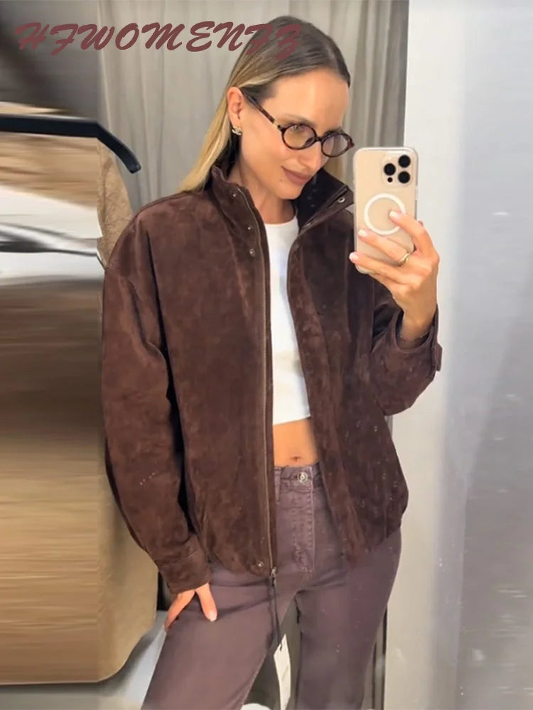Person wearing a brown jacket and taking a mirror selfie.