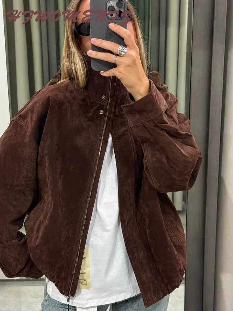 Person wearing a brown jacket taking a mirror selfie.