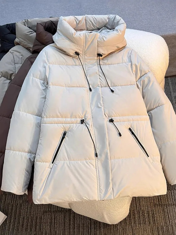 White puffer jacket with black zippers on a neutral background