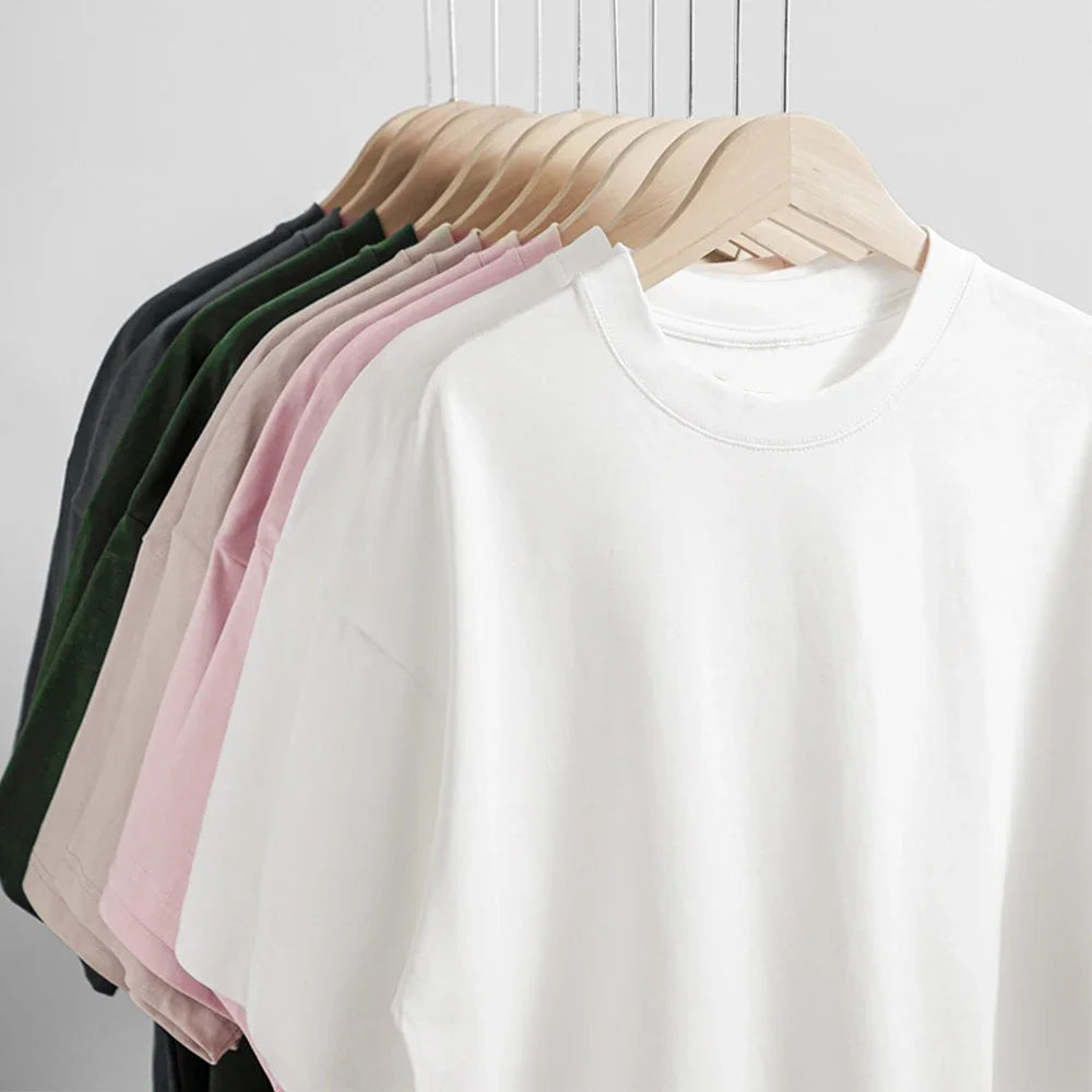 White shirt on a hanger with other shirts in various colors on a white background