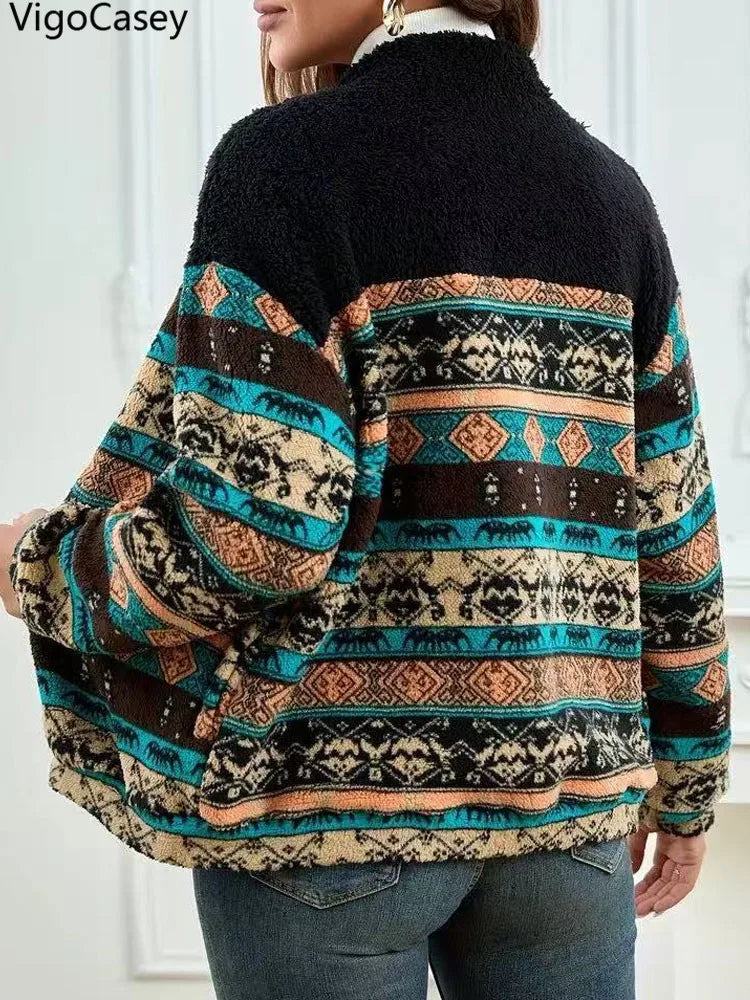 Person wearing a patterned jacket with a black top underneath, standing indoors.