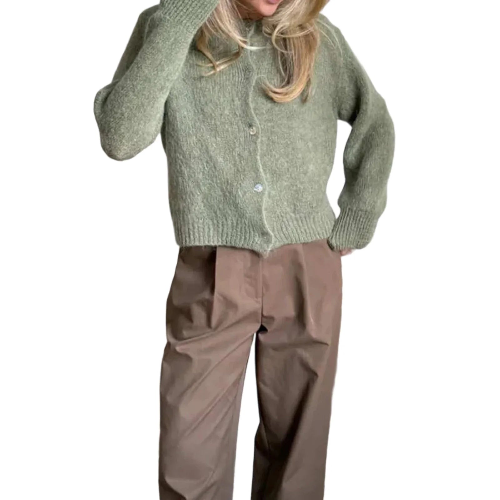Person wearing a green knitted cardigan and brown pants on a white background