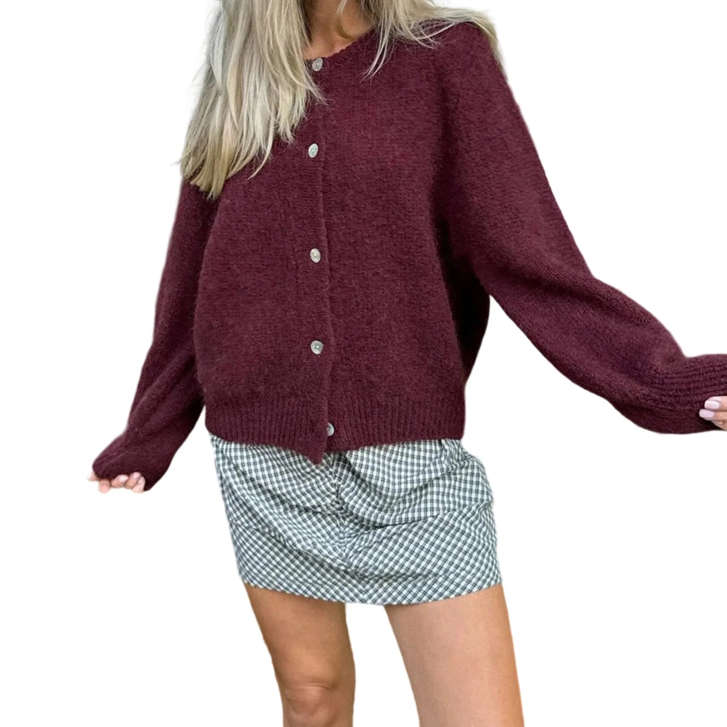 Person wearing a burgundy cardigan over a plaid skirt on a white background