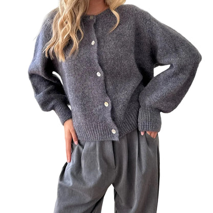 Person wearing a gray cardigan and pants on a white background