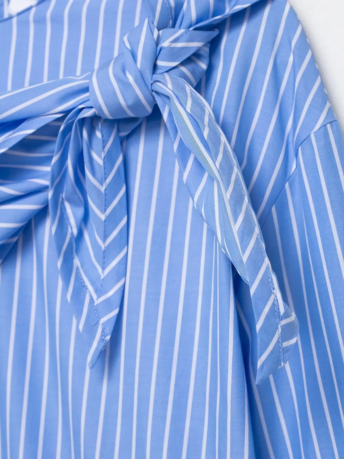 Close-up of a blue and white striped fabric with a knot, possibly from a garment.