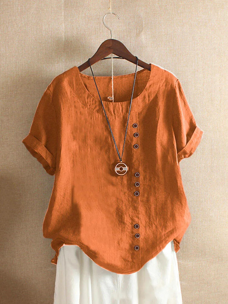 Orange shirt with buttons on a hanger against a beige background