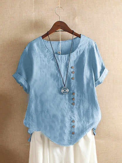 Light blue shirt with buttons on a hanger against a beige background