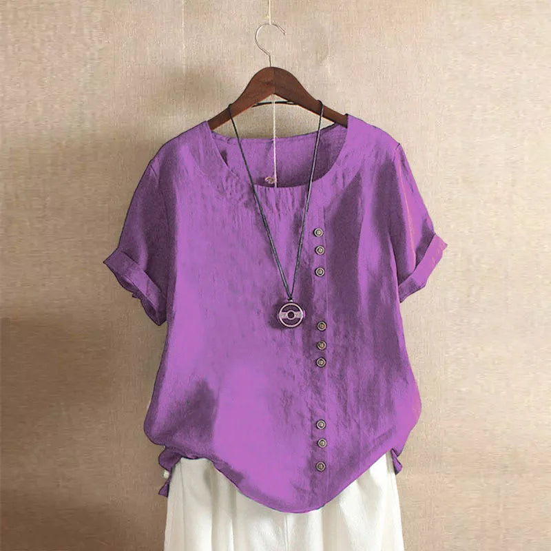 Purple shirt with buttons on a hanger against a beige wall
