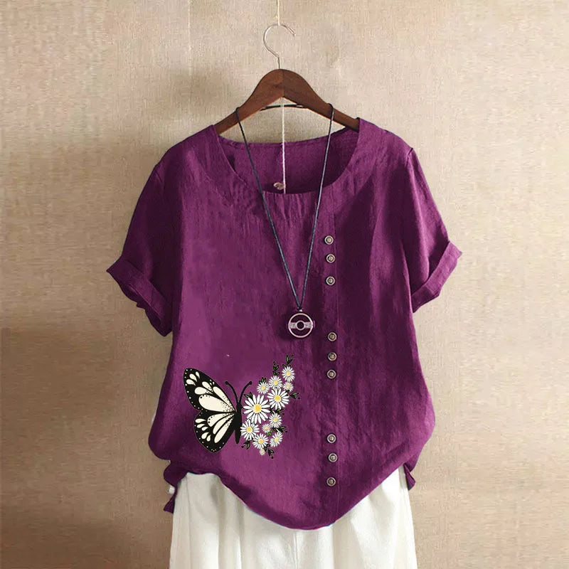 Purple shirt with butterfly design on a hanger against a beige wall