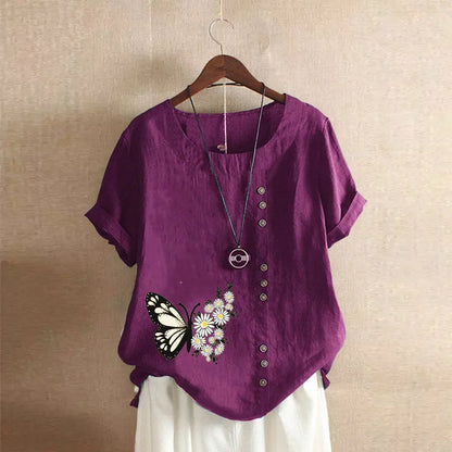 Purple shirt with butterfly design on a hanger against a beige wall