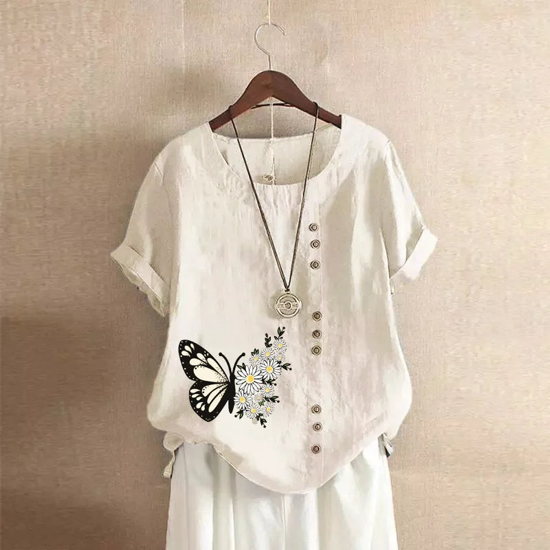 White shirt with butterfly design on a hanger against a beige wall